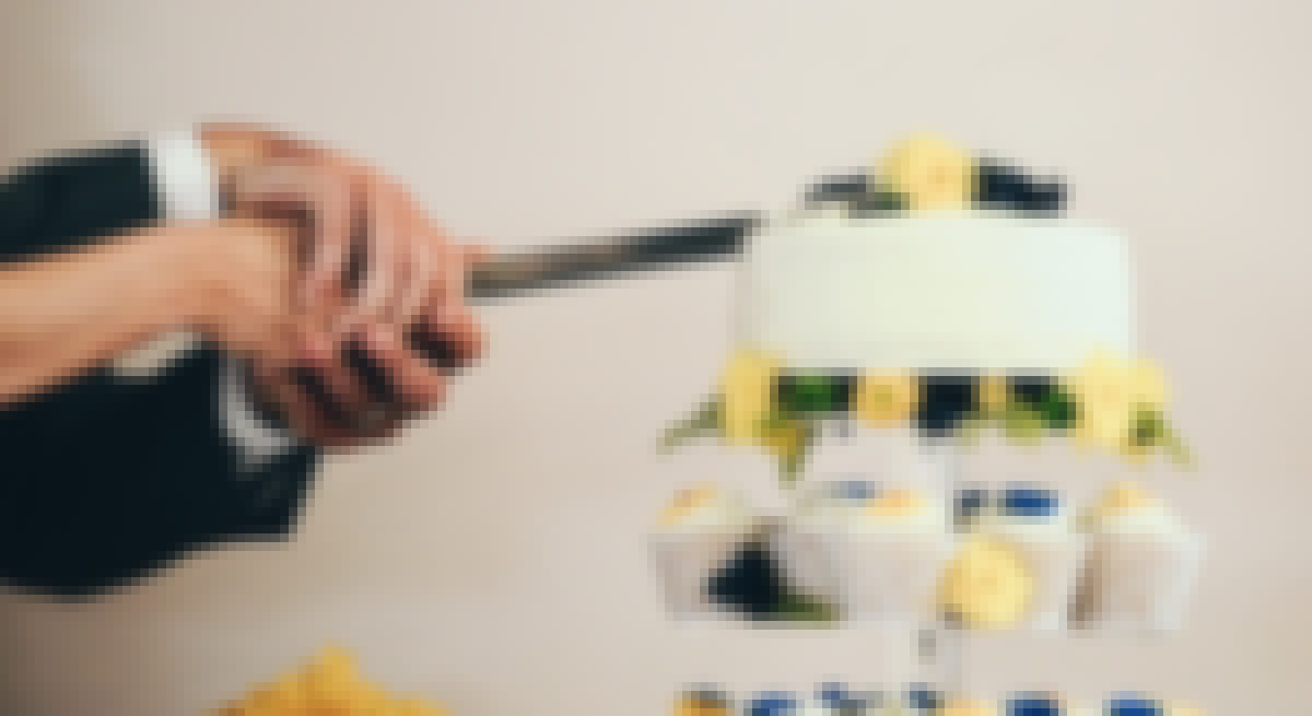 Photo d'un couple en train de découper leur gâteau de mariage