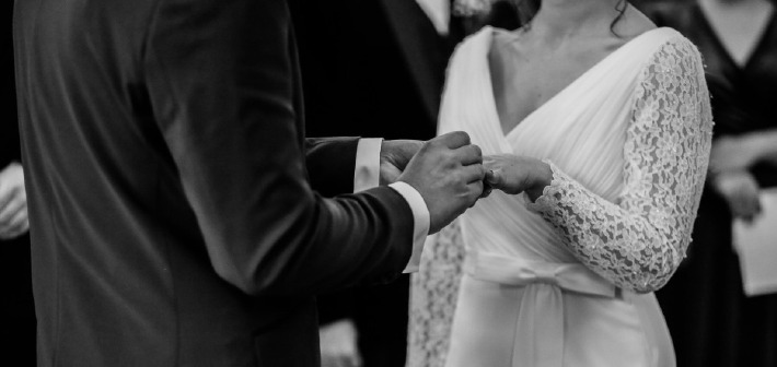 Photo d'un couple s'échangeant des alliances le jour de leur mariage civil à la mairie