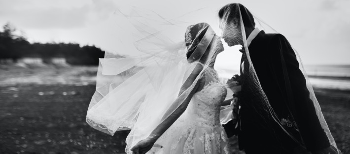 Picture of a couple kissing on their wedding day in France.