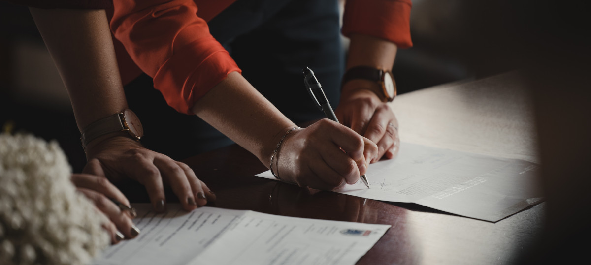 A person signing and prepararing documents.