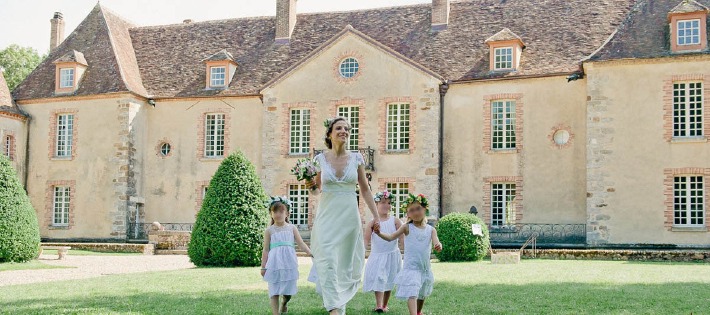 photo d'une jeune mariée entourée de ses enfants devant un château pour un mariage en Bourgogne