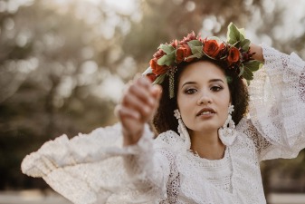 Une femme habillée avec une robe de mariée et une couronne de fleurs le jour de son mariage organisé sur le thème du mariage boho chic.