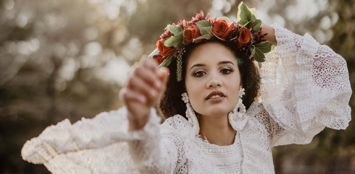 Une femme habillée en robe de mariée bohème chic pour son mariage avec une couronne de fleurs