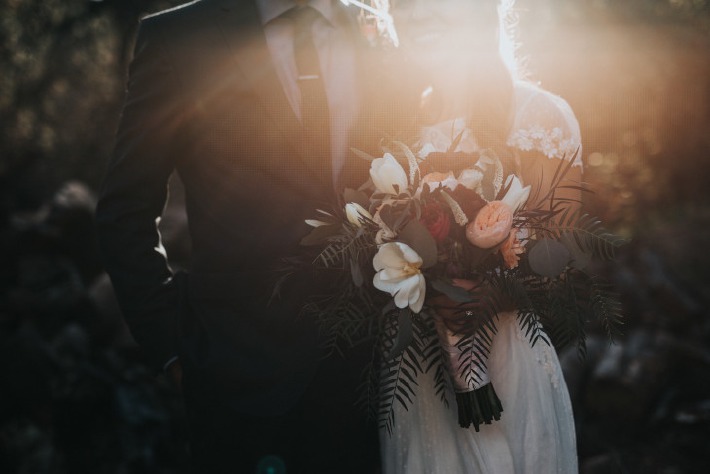 Couple de mariés portant un bouquet