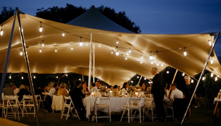 Décoration d'un mariage champêtre organisé sous une tente en extérieur au château de Bois Rigaud dans le Puy-de-Dôme