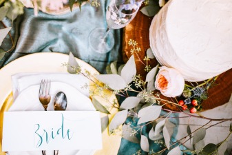 Photo de la décoration d'une table de mariage, réalisée avec des bougies, des fleurs et des nappes vintage