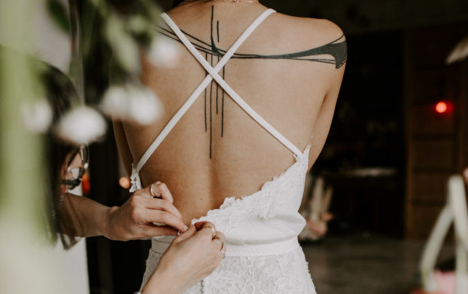 Photo d'Amandine Bardet, wedding planner en Auvernge, en train d'ajuster une robe de mariée