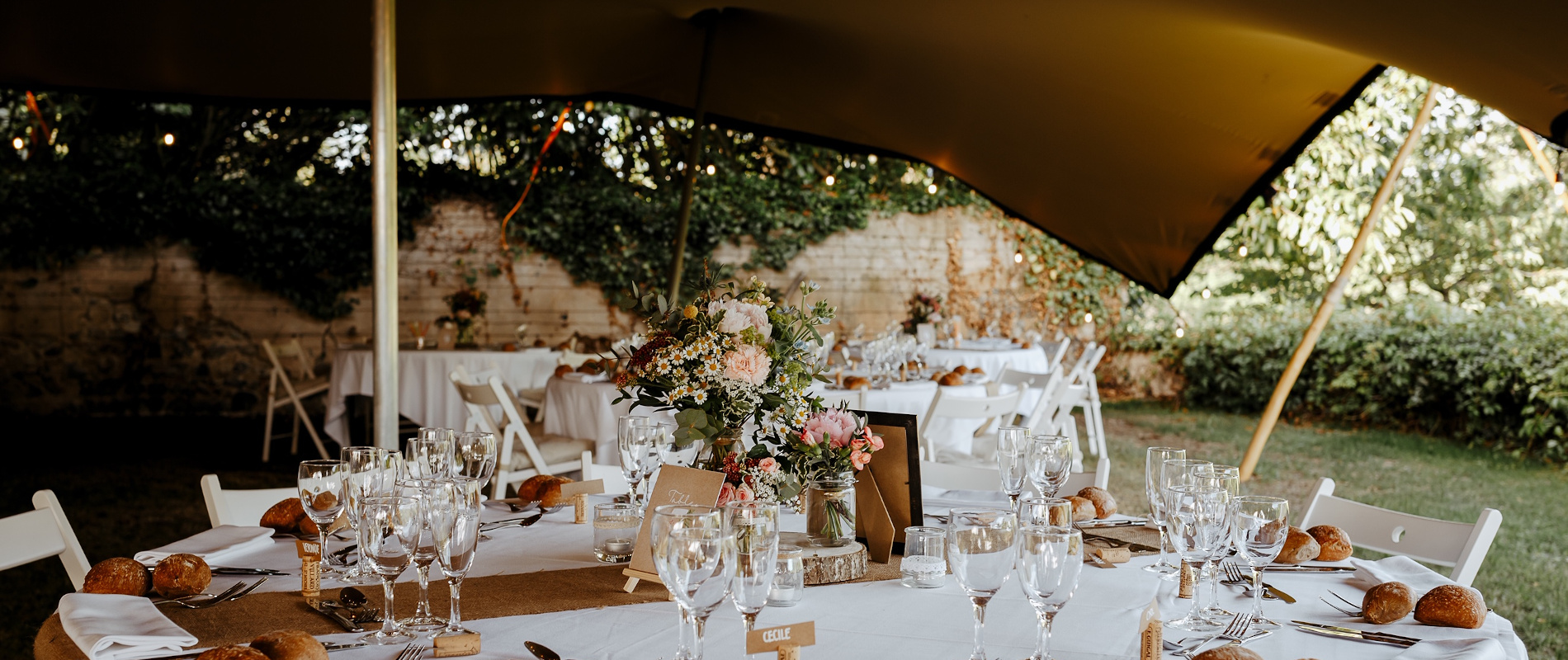 Photo d'un repas de mariage organisé en extérieur sous une tente nomade au château de Bois Rigaud dans le Puy-de-Dôme