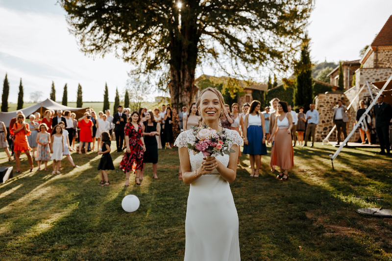 A bride throwing her bouquet during her wedding day at Chateau de Bois Rigaud