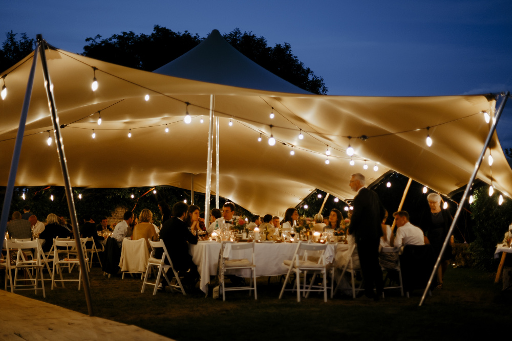 Alfresco wedding dinner celebrated under the marquee of Chateau de Bois Rigaud in France.